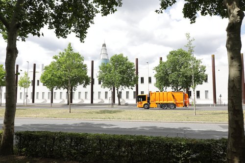 Abfallsammelfahrzeug zwischen Bäumen (rechts) auf der Museumsmeile