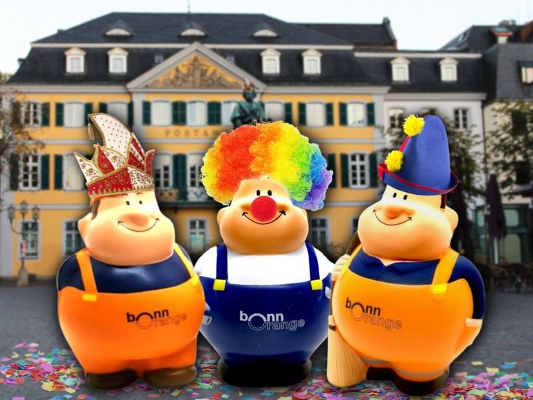 drei der bonnorange Maskottchen Bert in Verkleidung vor der Beethoven Statue in Bonn.