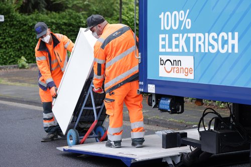Zwei Mitarbeiter der bonnorange beim Verladen von Elektrogroßgeräten mit in ein E-Fahrzeug