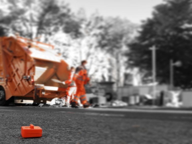 Fast Furniture: Abfallsammelfahrzeug Abfallsammelfahrzeug von bonnorange mit orangenem Wecker im Vordergrund